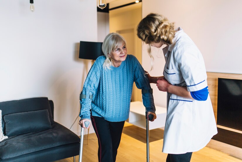Responder Assisting Elderly Woman in Her Home An elderly woman with crutches talks to a nurse in a cozy living room.